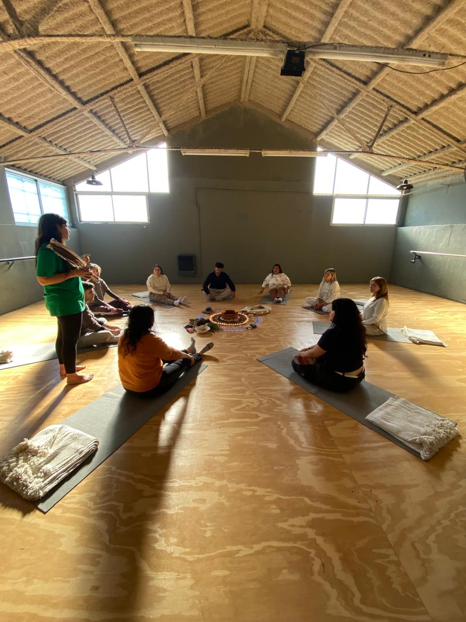 Círculo grupal en una sala amplia con altar central